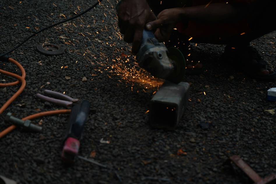 Two experienced fabricators reviewing a plasma cutter in a workshop setting
