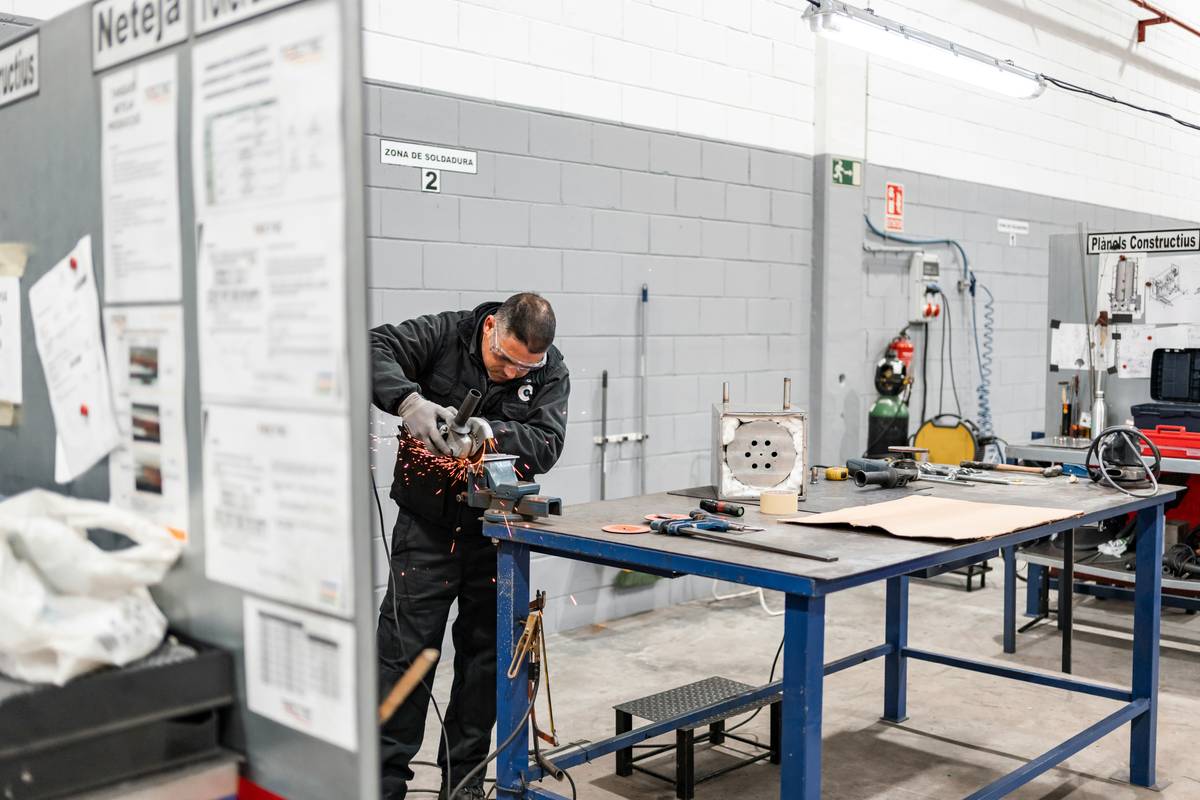 miller welder with plasma cutter in a home garage workshop cutting through steel plate